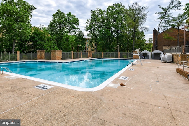 pool with fence and a patio area