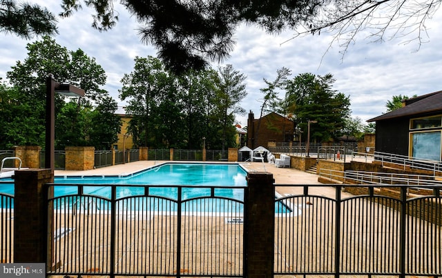 community pool featuring fence and a patio