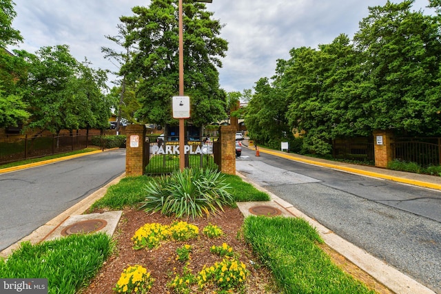 view of road featuring a gated entry and curbs
