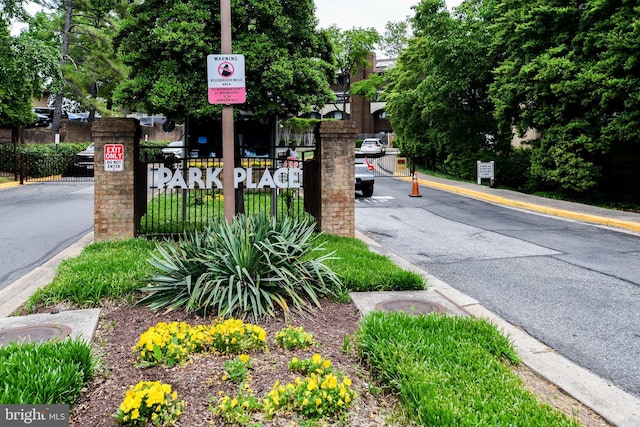 view of street featuring a gated entry, traffic signs, and curbs
