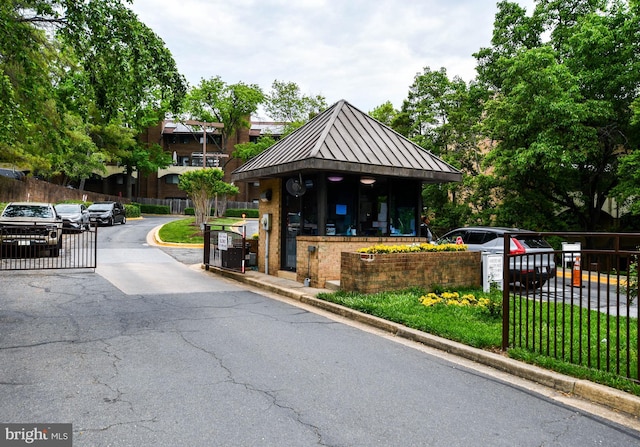 exterior space with a gated entry, a gate, and curbs