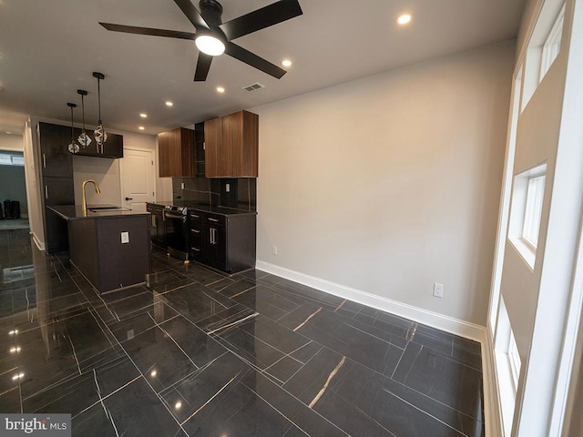 2005 N Lawrence St, Philadelphia, PA 19122 - kitchen with ceiling fan, baseboards, recessed lighting, dark countertops, and an island with sink