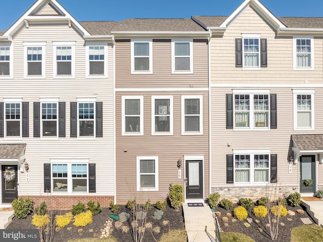 townhome / multi-family property featuring roof with shingles