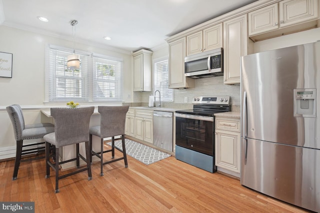 1614 Grace Church Rd, Silver Spring, MD 20910 - kitchen with light countertops, cream cabinets, a sink, light wood finished floors, and appliances with stainless steel finishes