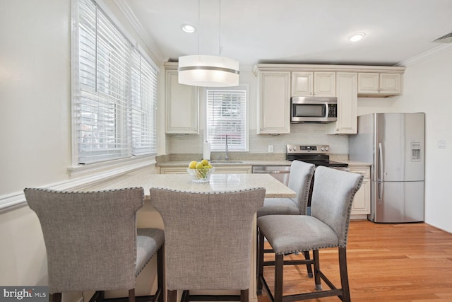 1614 Grace Church Rd, Silver Spring, MD 20910 - kitchen with crown molding, pendant lighting, a kitchen breakfast bar, a sink, and stainless steel appliances
