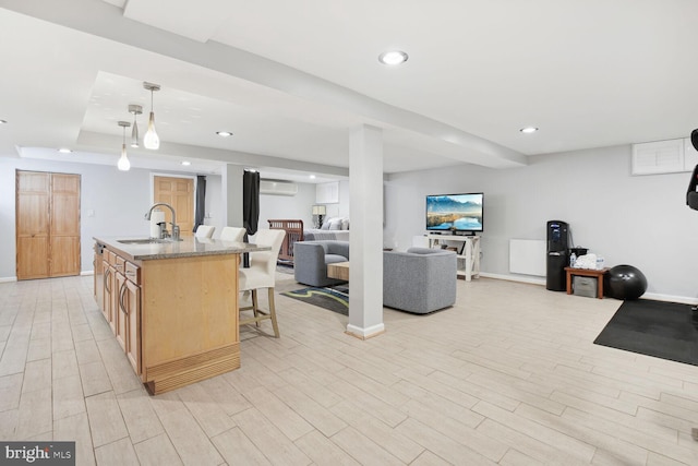 1614 Grace Church Rd, Silver Spring, MD 20910 - kitchen featuring a sink, a breakfast bar area, light wood-style flooring, open floor plan, and a wall unit AC