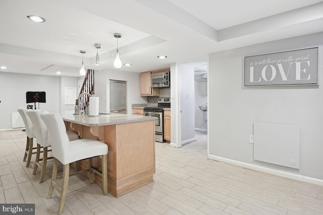 1614 Grace Church Rd, Silver Spring, MD 20910 - kitchen featuring a tray ceiling, a breakfast bar area, a sink, light countertops, and stainless steel appliances
