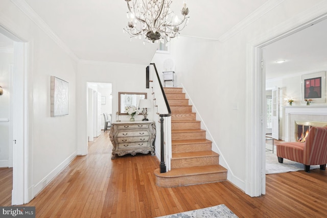 1614 Grace Church Rd, Silver Spring, MD 20910 - stairway with wood-type flooring, baseboards, crown molding, and an inviting chandelier