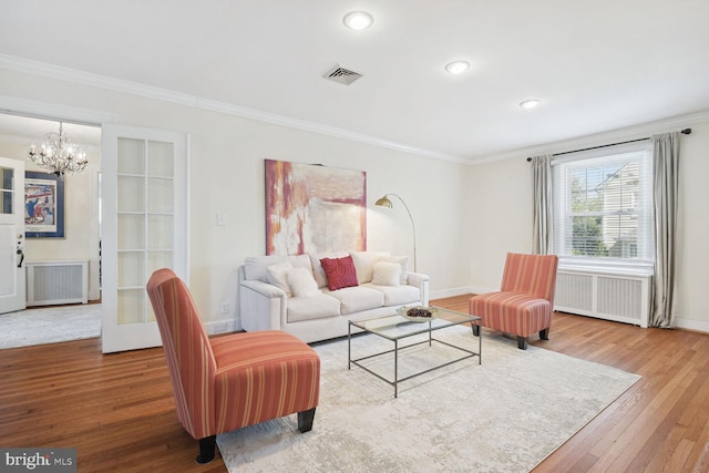 1614 Grace Church Rd, Silver Spring, MD 20910 - living room with crown molding, wood finished floors, radiator heating unit, and an inviting chandelier