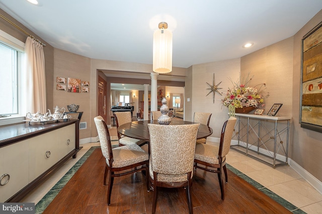 dining space with decorative columns, recessed lighting, baseboards, and wood finished floors
