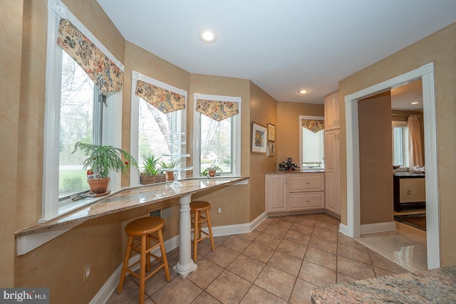 interior space featuring recessed lighting, baseboards, light stone counters, and light tile patterned flooring
