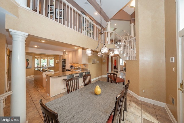 dining area featuring baseboards, ornate columns, light tile patterned flooring, and stairway
