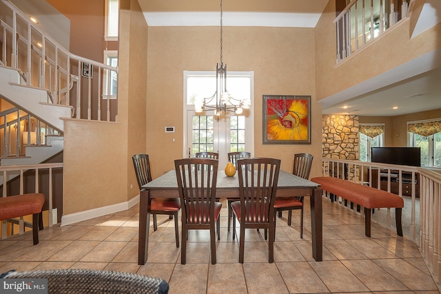 dining room featuring a chandelier, tile patterned flooring, and a towering ceiling