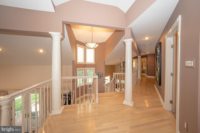 corridor featuring baseboards, recessed lighting, an upstairs landing, ornate columns, and wood finished floors