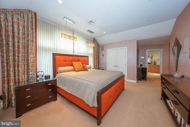 bedroom with light colored carpet, a closet, visible vents, and vaulted ceiling