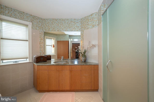 bathroom featuring a shower stall, tile patterned floors, vanity, and tile walls