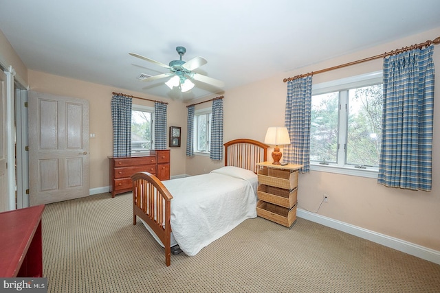 bedroom with visible vents, baseboards, light colored carpet, and a ceiling fan