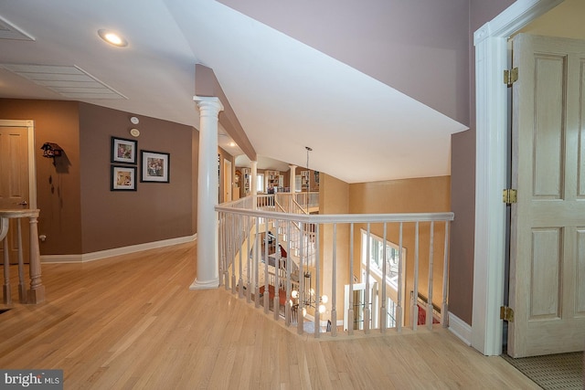 hallway featuring baseboards, wood finished floors, and lofted ceiling