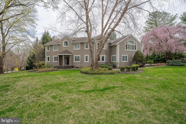 view of front of house with stucco siding and a front yard