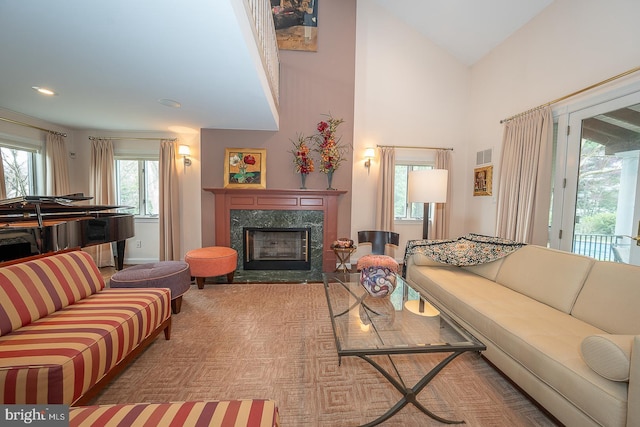 living room featuring a high end fireplace, visible vents, and baseboards