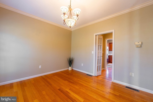 unfurnished room featuring visible vents, crown molding, baseboards, a chandelier, and light wood-style flooring
