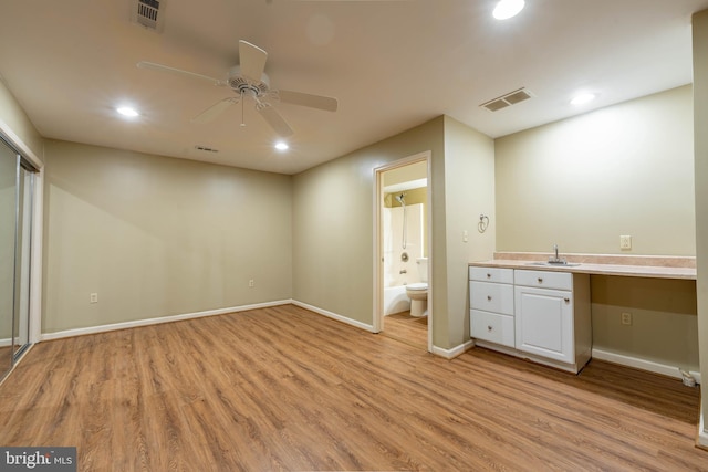 unfurnished bedroom featuring visible vents, light wood-type flooring, and a sink