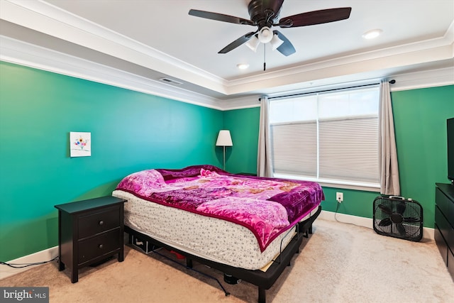 bedroom featuring ornamental molding, a ceiling fan, visible vents, a tray ceiling, and carpet