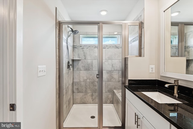 full bath with a shower stall and vanity