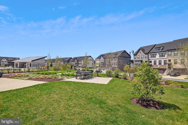 view of community featuring a patio area, a residential view, and a lawn