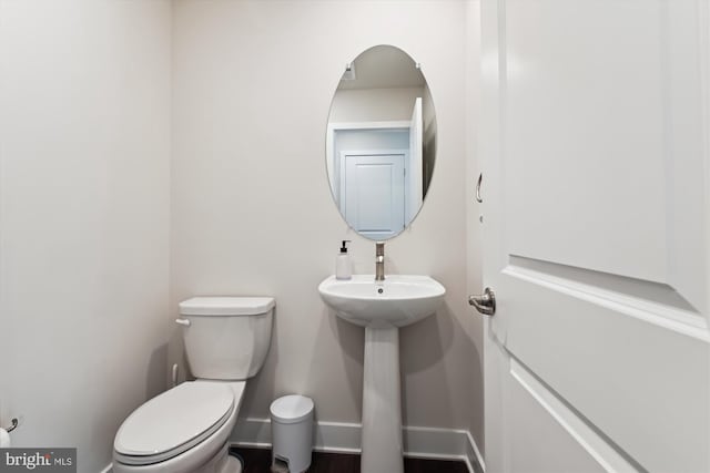 bathroom with toilet and baseboards