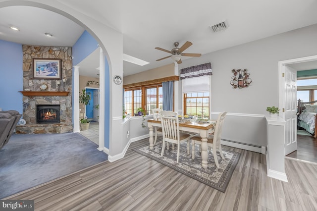180 Featherbed Ln, Pilesgrove, NJ 08098 - dining room with visible vents, a ceiling fan, wood finished floors, a fireplace, and a baseboard radiator