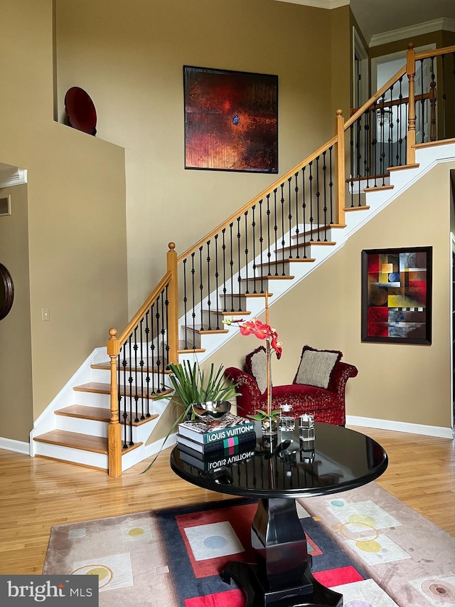 1388 Old Barn Cir, Downingtown, PA 19335 - staircase featuring wood finished floors, a towering ceiling, baseboards, and crown molding