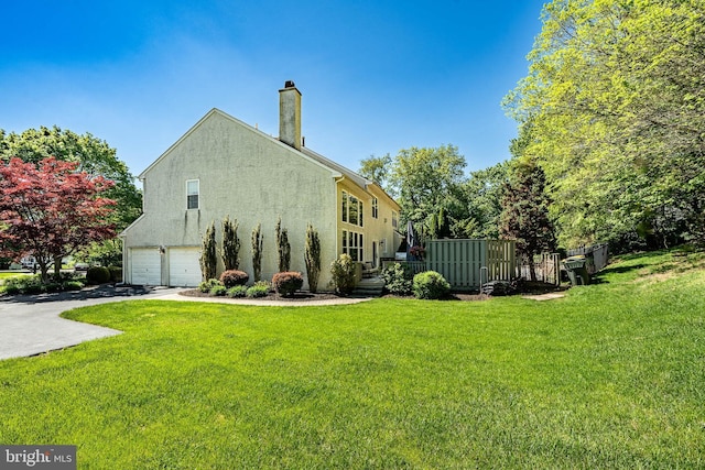 1388 Old Barn Cir, Downingtown, PA 19335 - view of home's exterior featuring stucco siding, driveway, a chimney, a garage, and a yard