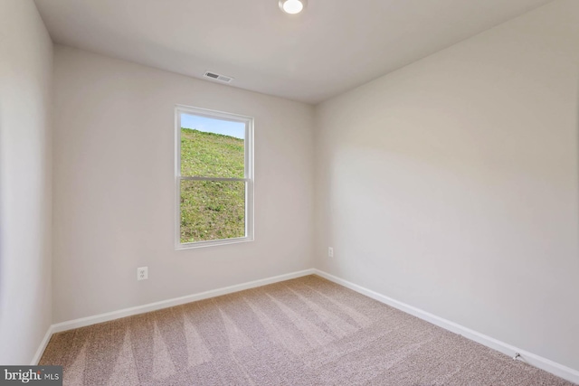 carpeted spare room with visible vents and baseboards