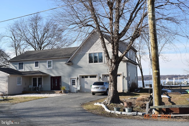view of front of house with a water view, aphalt driveway, and an attached garage