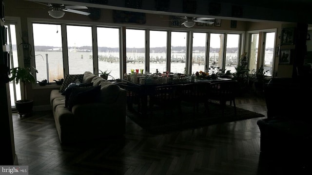 sunroom featuring a water view