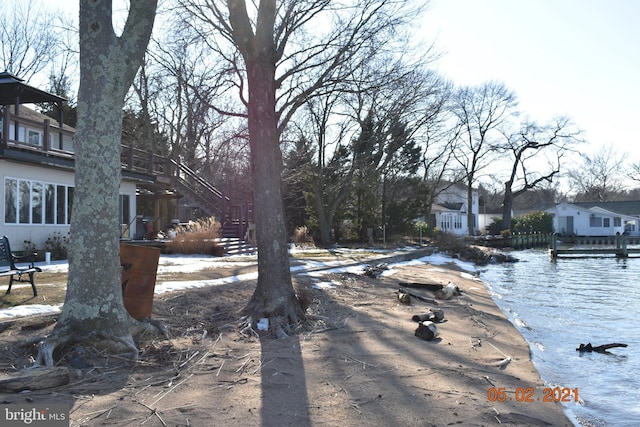 view of yard featuring a water view and stairway