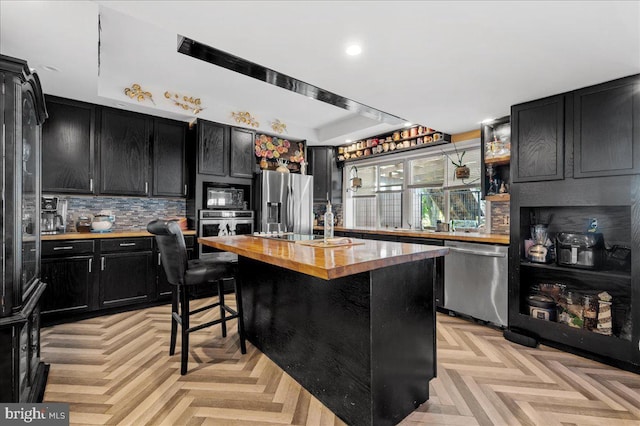280 Hollywood Beach Rd, Chesapeake City, MD 21915 - kitchen with dark cabinetry, butcher block counters, appliances with stainless steel finishes, decorative backsplash, and recessed lighting