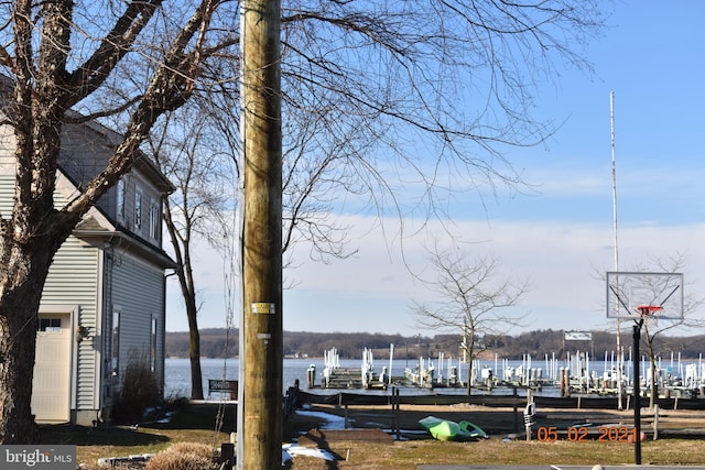 exterior space with boat lift, a water view, and a boat dock