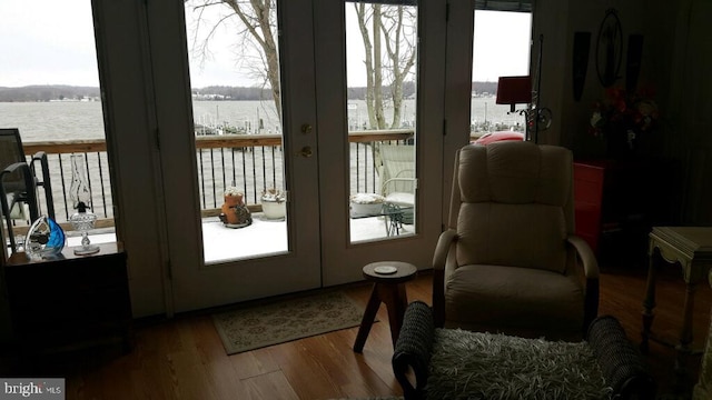 entryway featuring french doors, wood finished floors, and a water view