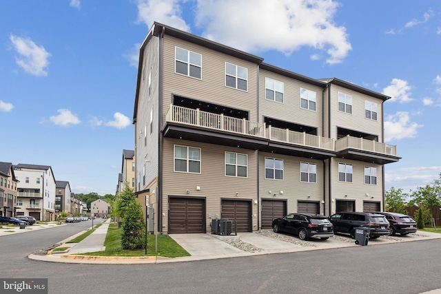 4902 Longmire Way Unit 24, Chantilly, VA 20151 - back of house featuring central AC unit, an attached garage, a residential view, driveway, and a balcony