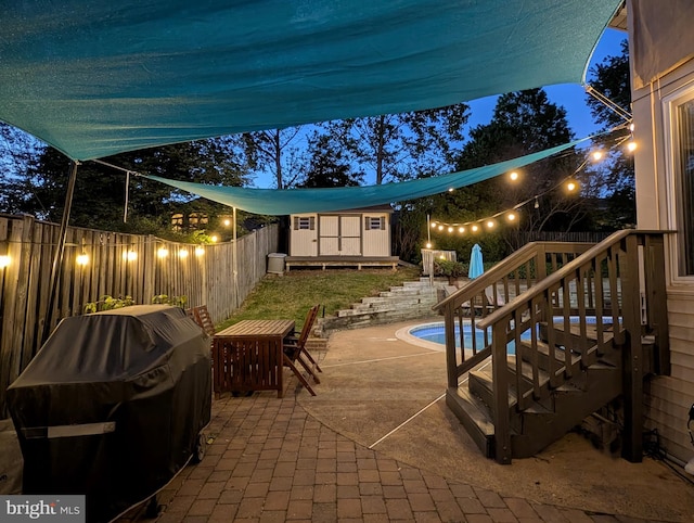 7306 Wayne Dr, Annandale, VA 22003 - patio at night featuring grilling area, an outbuilding, a fenced in pool, a fenced backyard, and a storage unit