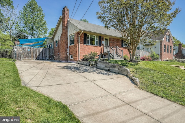 7306 Wayne Dr, Annandale, VA 22003 - view of front facade featuring a front lawn, fence, a chimney, brick siding, and concrete driveway
