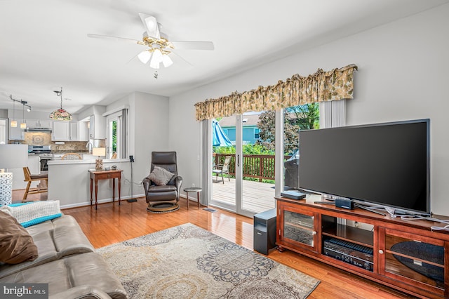 living area featuring light wood-style floors, ceiling fan, and visible vents