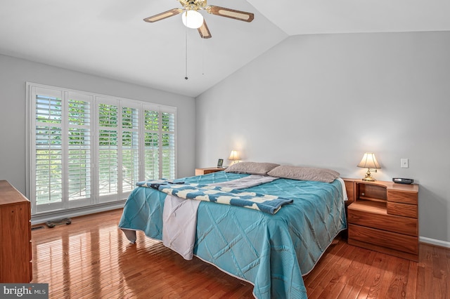 bedroom with a ceiling fan, wood finished floors, and lofted ceiling