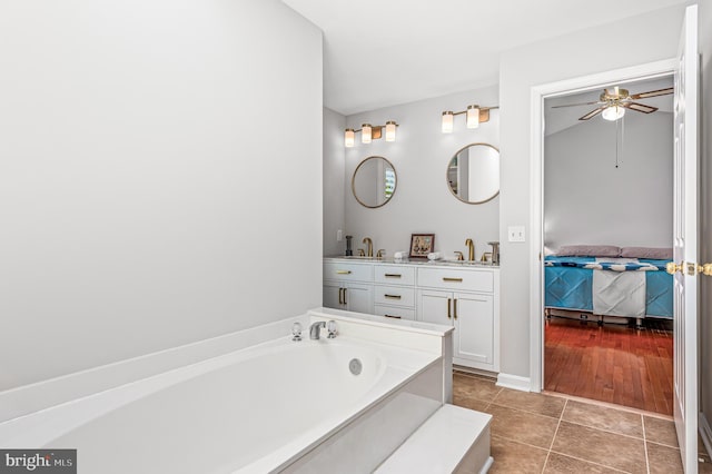 bathroom featuring a sink, tile patterned flooring, a ceiling fan, ensuite bathroom, and a garden tub