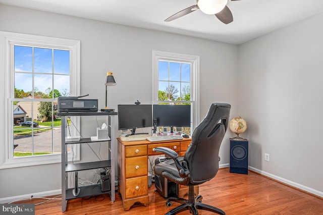office space featuring baseboards, a ceiling fan, and wood finished floors