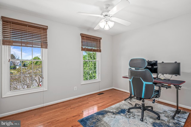 office space featuring baseboards, ceiling fan, and wood finished floors