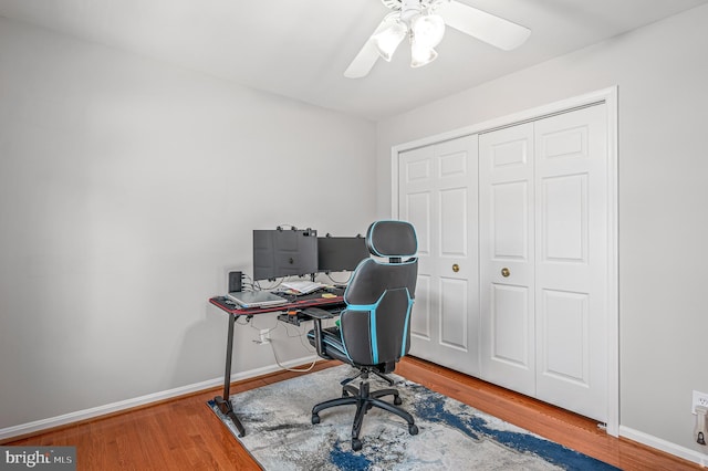 office space featuring baseboards, a ceiling fan, and wood finished floors