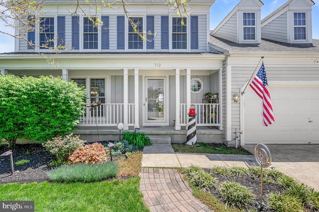 view of exterior entry with an attached garage and a porch